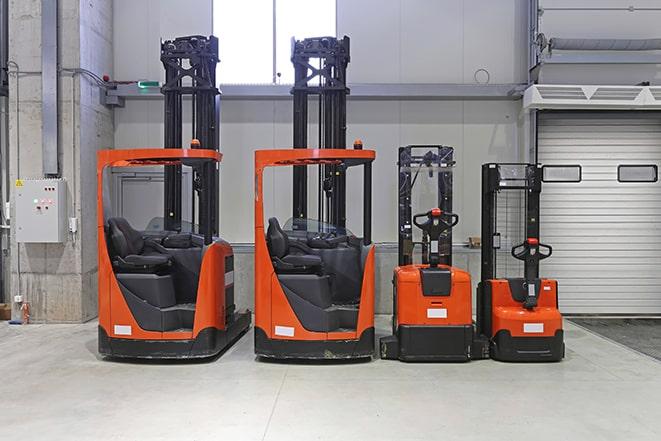 a row of forklifts parked in a manufacturing facility